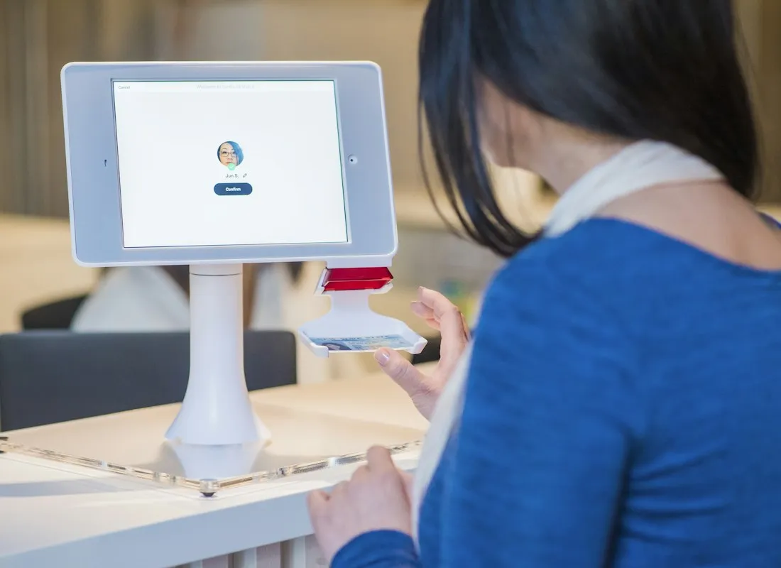 Een bezoeker gebruikt een digitaal scherm bij de ontvangst