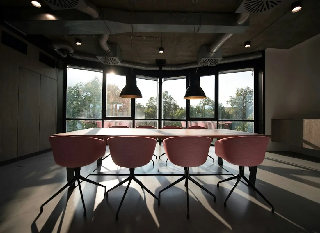 Vergaderruimte met stoelen, hanglampen en grote ramen