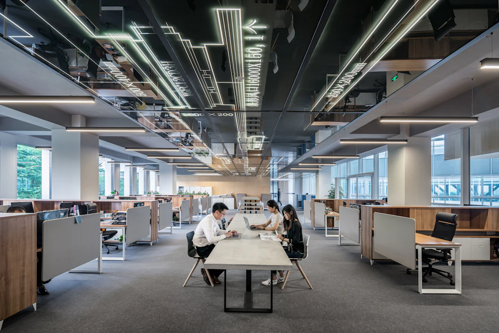 Open kantoor met werkplekken en zichtbare plafondinstallaties
